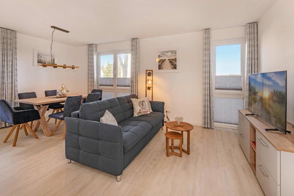 a living room with a couch and a table at FeWo Meerzeit Bernsteinquartier in Loddin