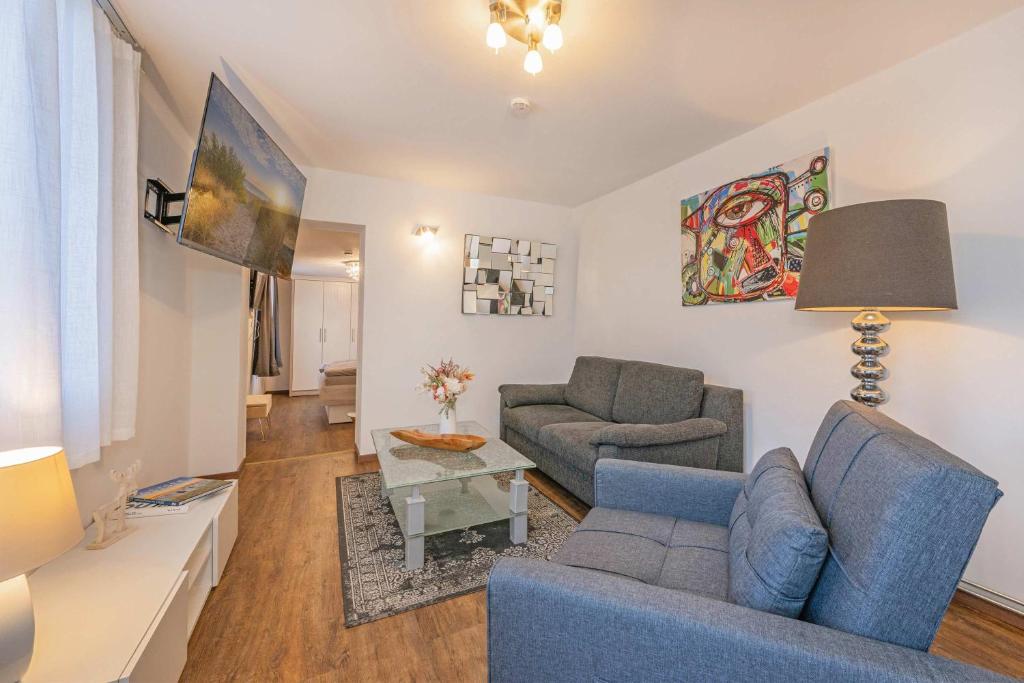 a living room with a blue couch and a table at Bungalow "Giny" in Bansin