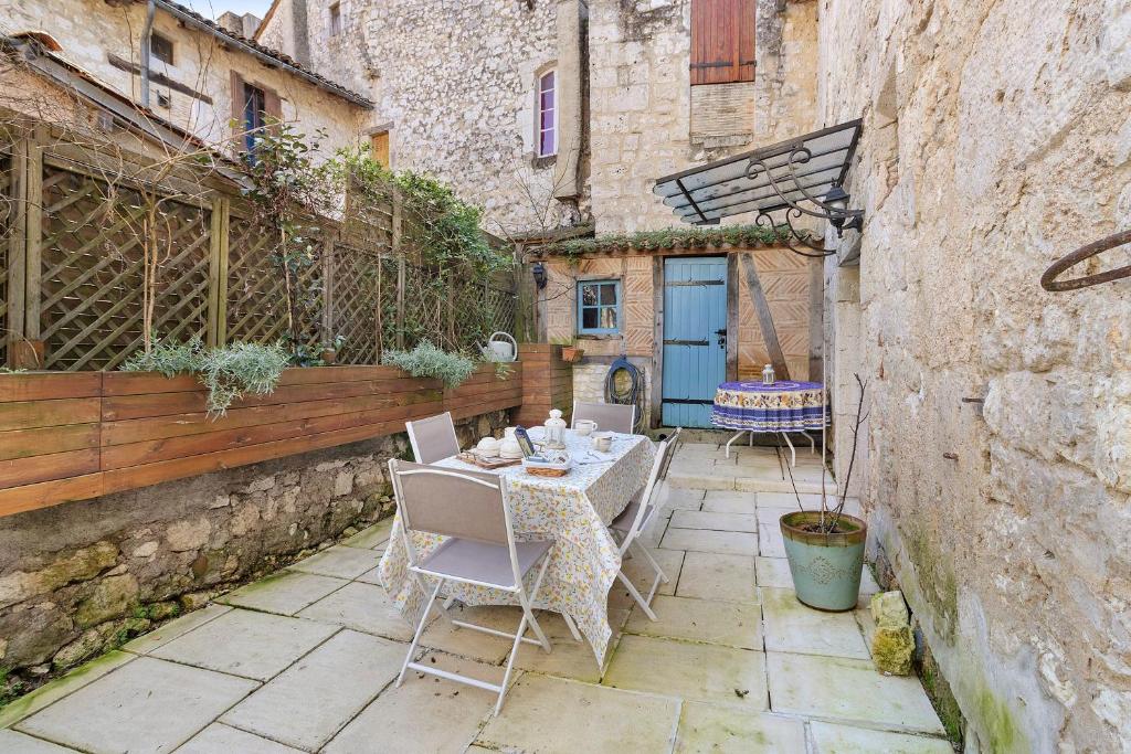 a patio with a table and chairs in an alley at Maison historique en pierre in Issigeac