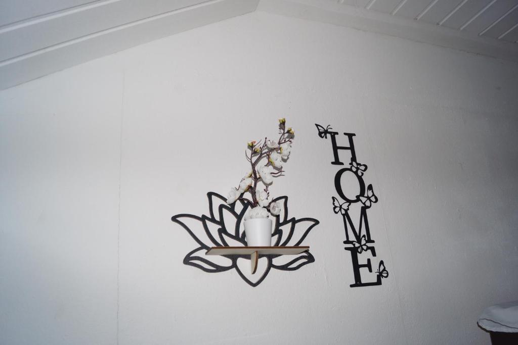 a sign on a wall with a flower and a clock at Quiet And Renovated Apartment in Schwendi
