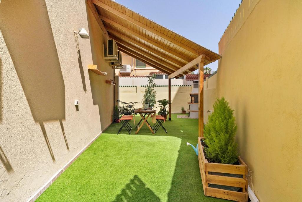 an outdoor patio with a table and green grass at Colina Verde Maspalomas in Maspalomas