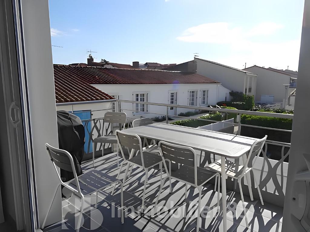 a patio with a table and chairs on a balcony at La Maison Du Marché - Balcon in La Tranche-sur-Mer