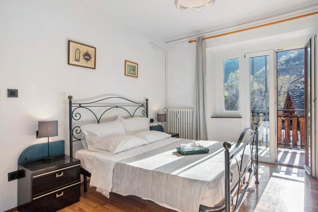 a bedroom with a bed and a large window at Casa Tua - Arvier in Arvier