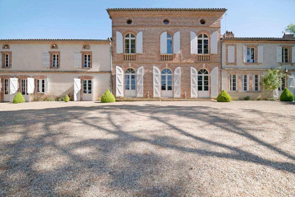 a large brick house with a large driveway at Maison d'hôtes de Gailhaguet in Verfeil