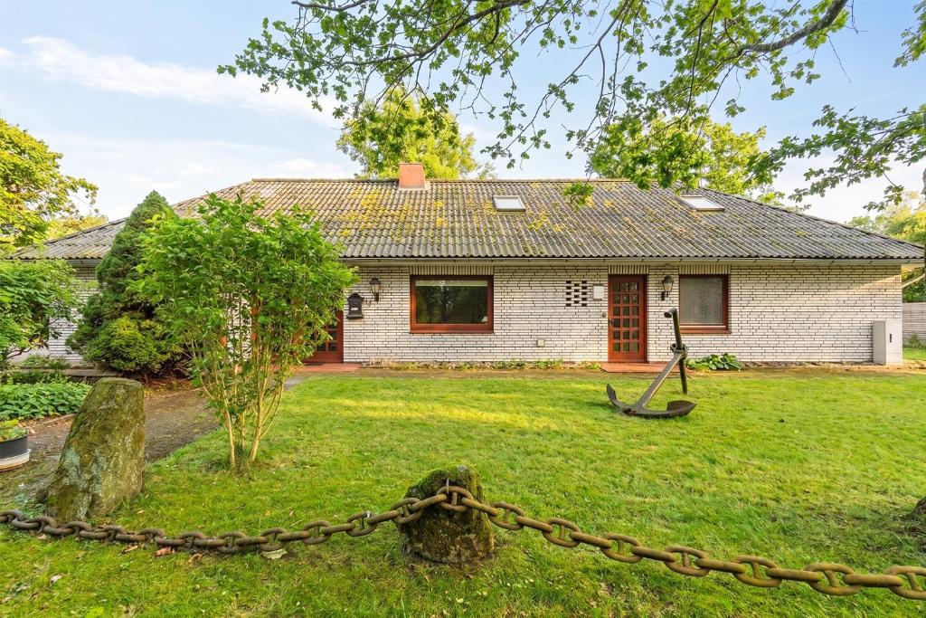 a house with a chain in front of a yard at De Maade in Enge-Sande