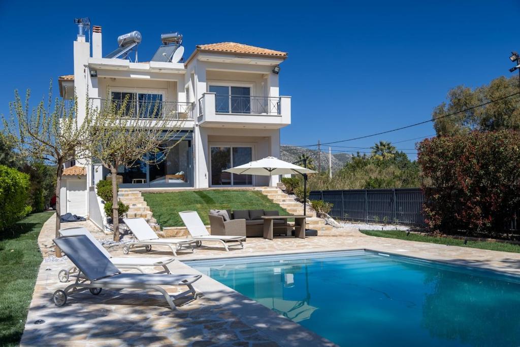 a villa with a swimming pool in front of a house at Blue Pine Villa in Marathon