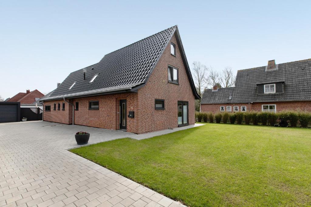 a brick house with a lawn in front of it at Ferienwohnung Emilia in Garding