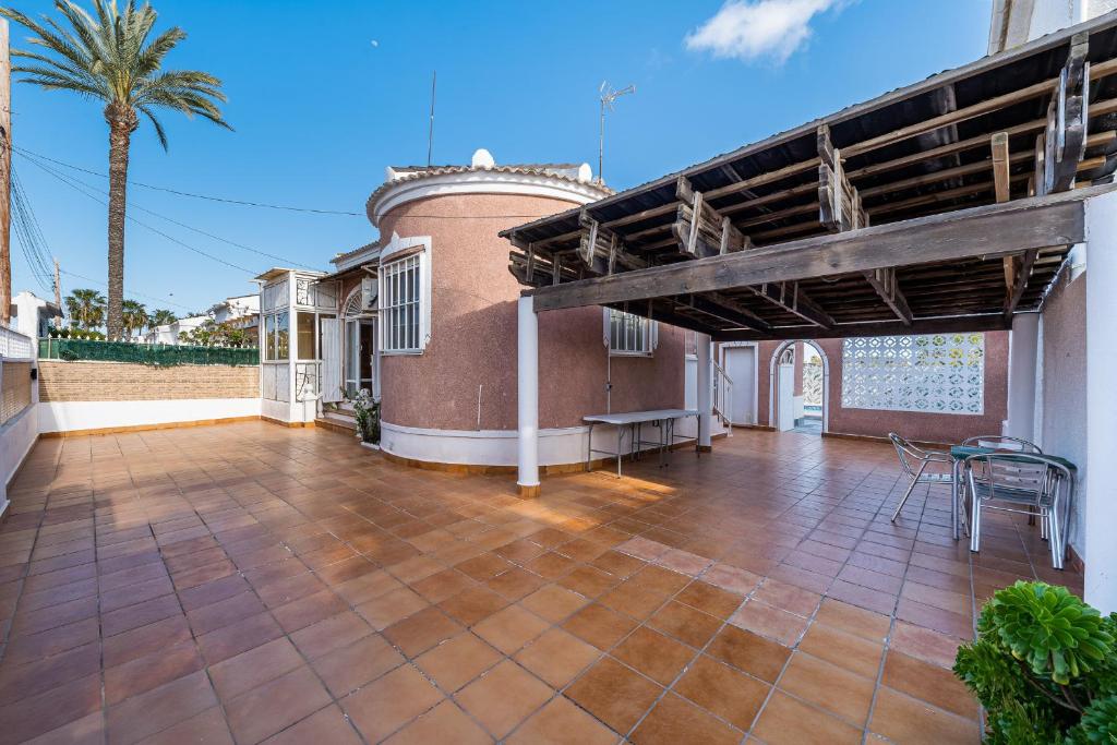 an outdoor patio with a wooden pergola at Chalet del Lago in Torrevieja