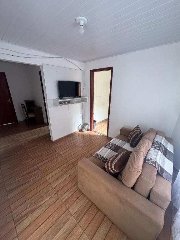 a living room with a couch and a television at Família Ebeneze in Santa Maria Madalena