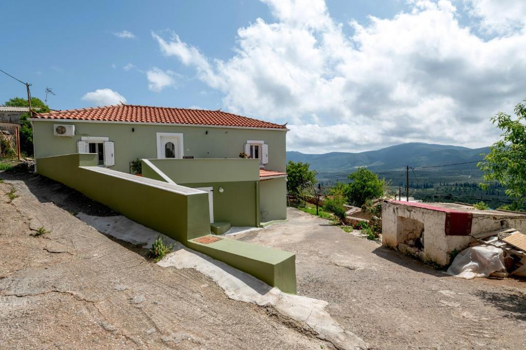 a house on a hill with a staircase in front of it at Traditional House in Velies in Áyios Sarándos