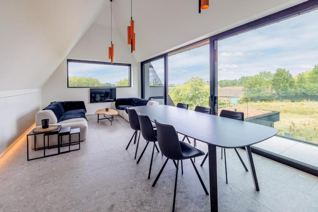 a living room with a large table and chairs at Apartment L'O Reine, B&B in Sint-Pieters-Leeuw