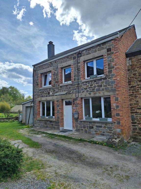 a brick house with a white door and windows at Ma maison de famille in Saint-Hubert