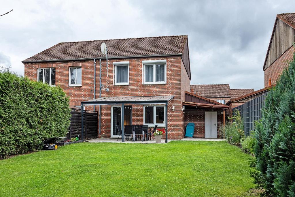 a brick house with a porch and a lawn at Ferienhaus Heide in Bad Fallingbostel