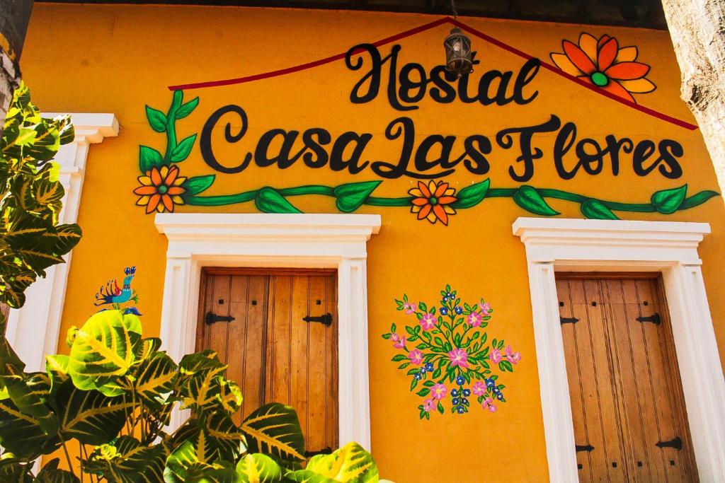 a sign on the side of a building with two windows at Hostal Casa Las Flores in Masaya