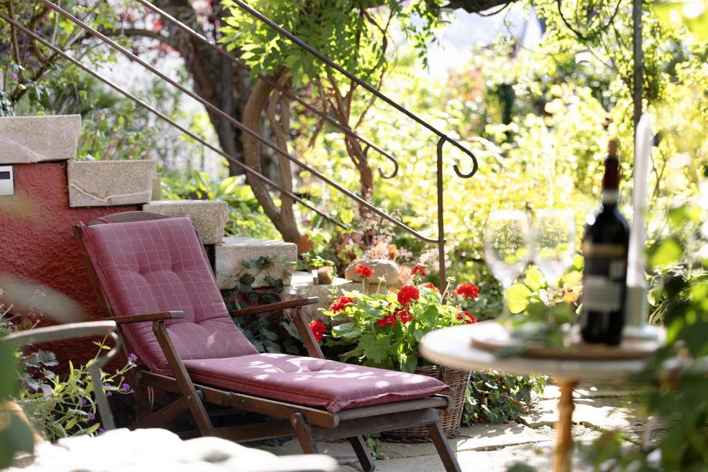 a patio with a chair and a table with a bottle of wine at Ferienwohnung Zur Alten Scheune in Balingen