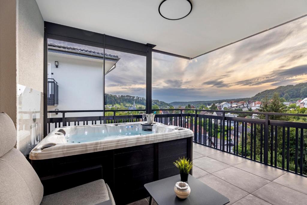 a bath tub in a room with a balcony at Egge Resort 7f mit Whirpool u Sauna in Altenbeken