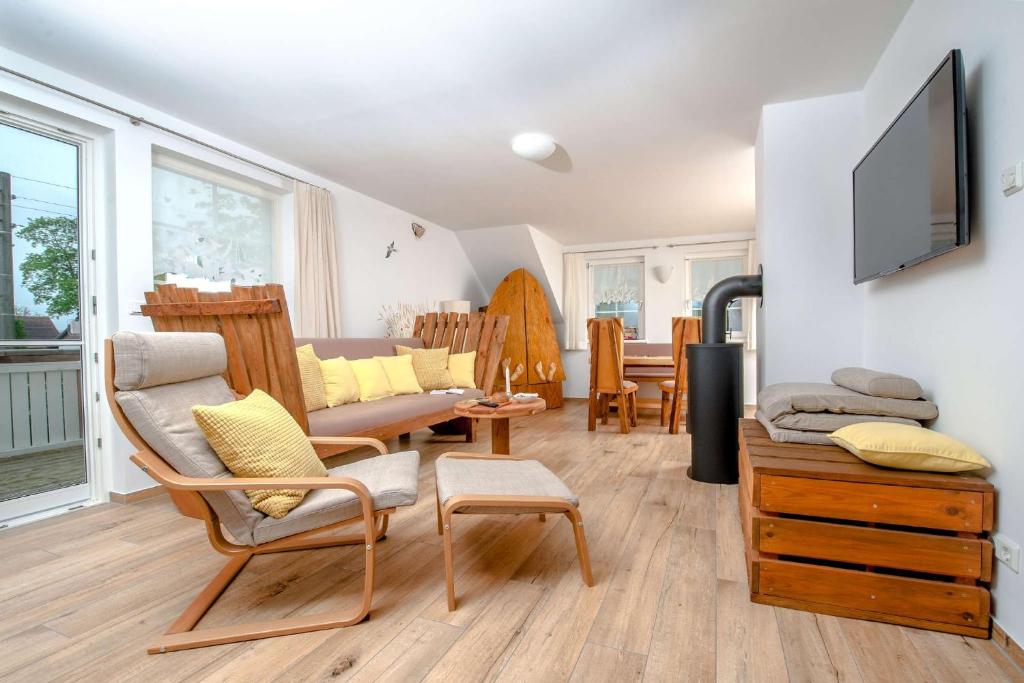 a living room with a couch and a tv on a wall at Ferienwohnung Heuschober in Neuendorf am See