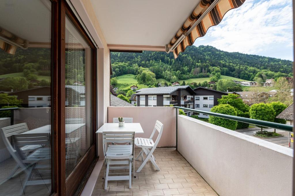 a balcony with a table and chairs and a view at Résidence du parc in Thônes