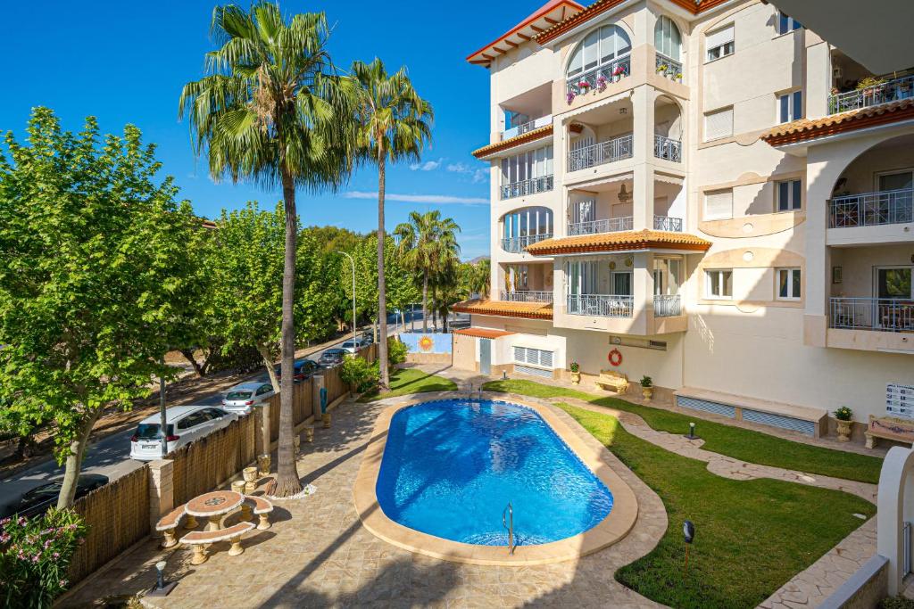 an apartment with a swimming pool in front of a building at Rotonda Spaniahome in L'Alfàs del Pi