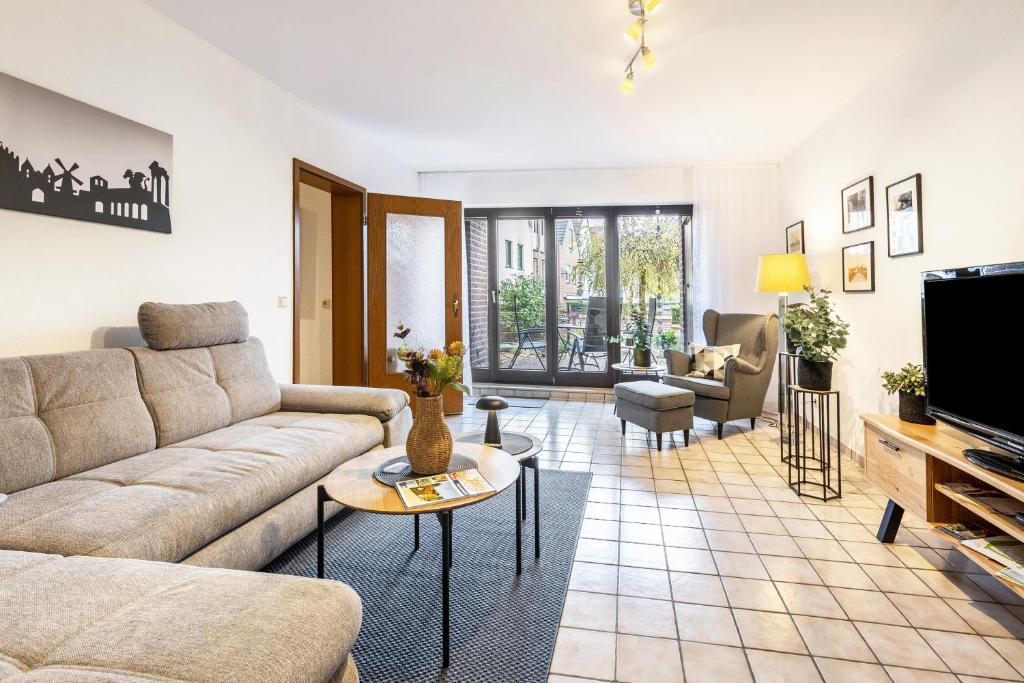 a living room with a couch and a tv at Ferienwohnung an der Kriemhildmühle in Xanten