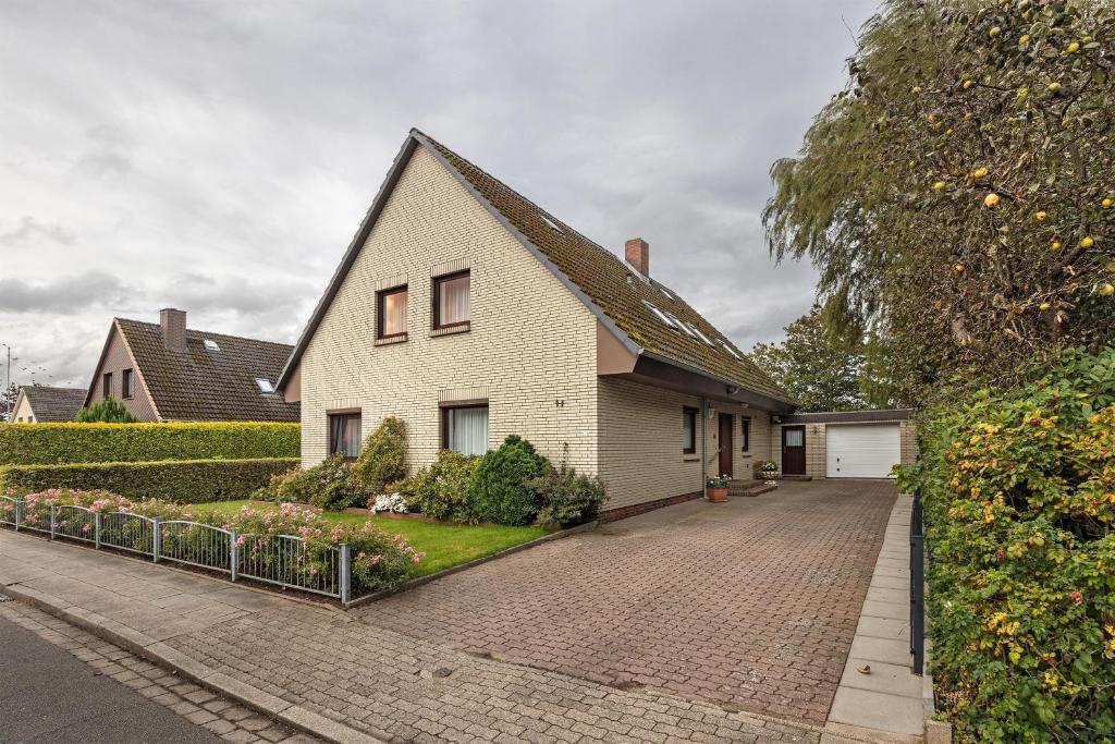 a white house with a brick driveway at Haus Stoldt in Meldorf