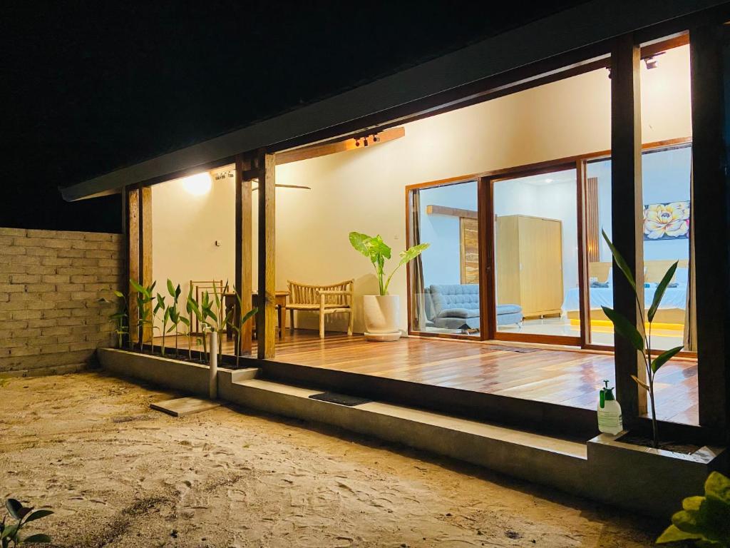 a living room with large windows and a wooden floor at Yaya BCB in Gili Meno