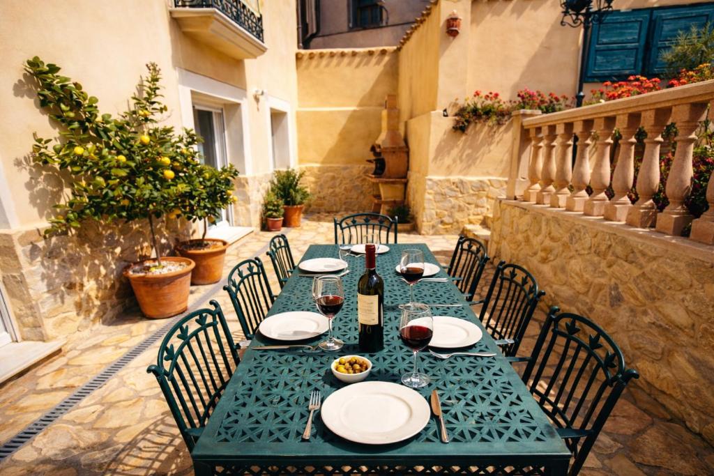 a green table with chairs and a bottle of wine at El Jardin Secreto in Oria