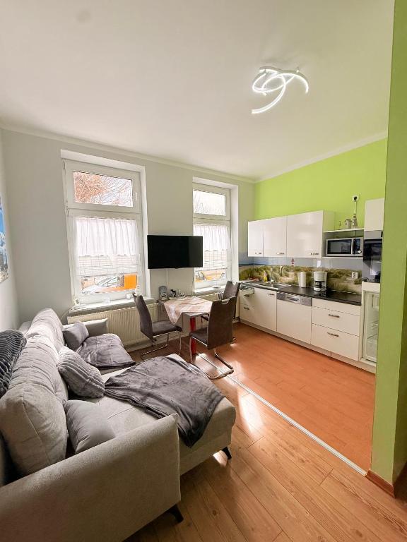 a living room with a couch and a kitchen at Meeresbriese Warnemünde in Warnemünde