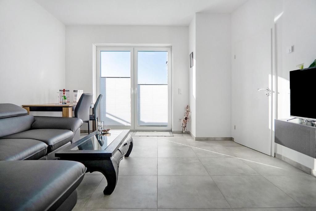 a living room with a couch and a table at Neubau Ferienwohnung mit Balkon in Gronau