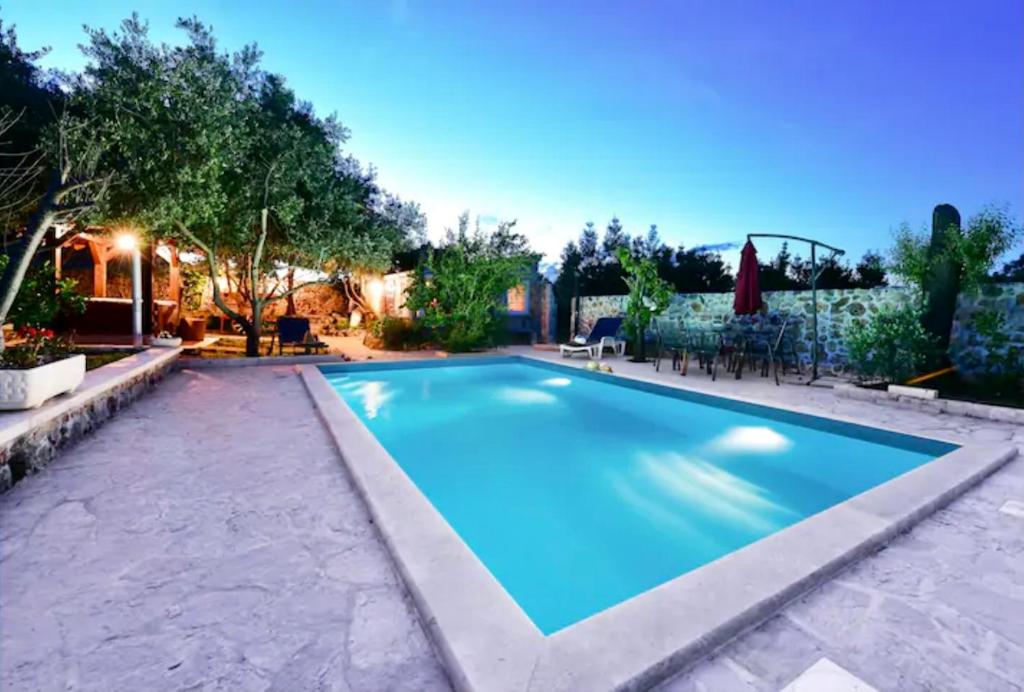 a swimming pool in a backyard at Robinson House with Pool & Seaview in Ždrelac