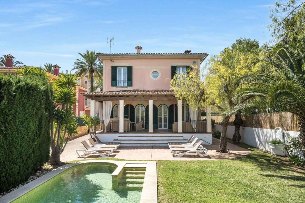 a house with a swimming pool in front of a yard at Villa Playa Felostal in Palma de Mallorca
