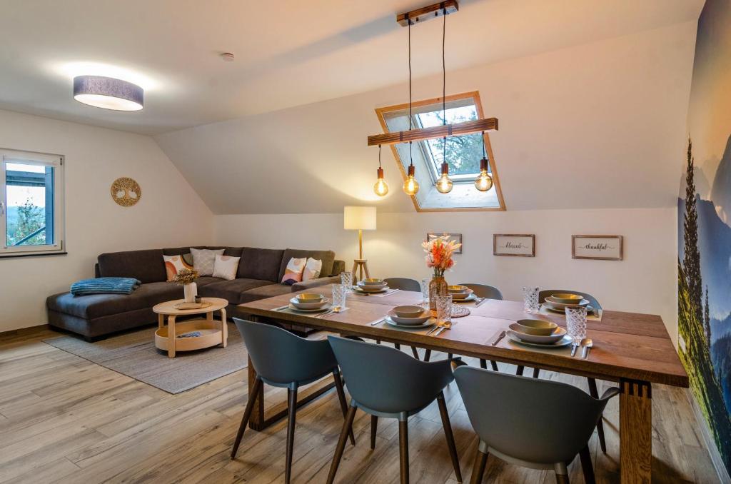 a dining room and living room with a table and chairs at Appartement Bergblick in Stockach