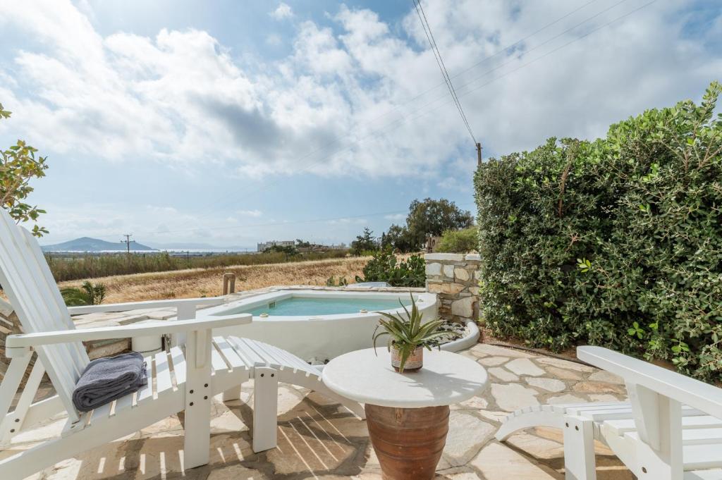 a patio with a table and chairs and a swimming pool at Aeolos Villa Cleo in Agkidia