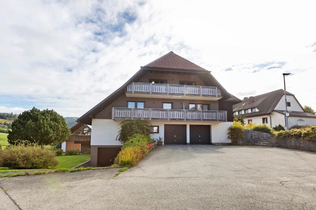 a large house with a balcony and a driveway at Haus Barbara in Bernau im Schwarzwald