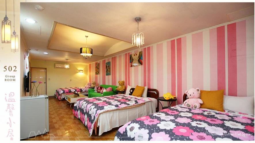 a room with three beds with pink and white stripes at Genial House in Jiaoxi
