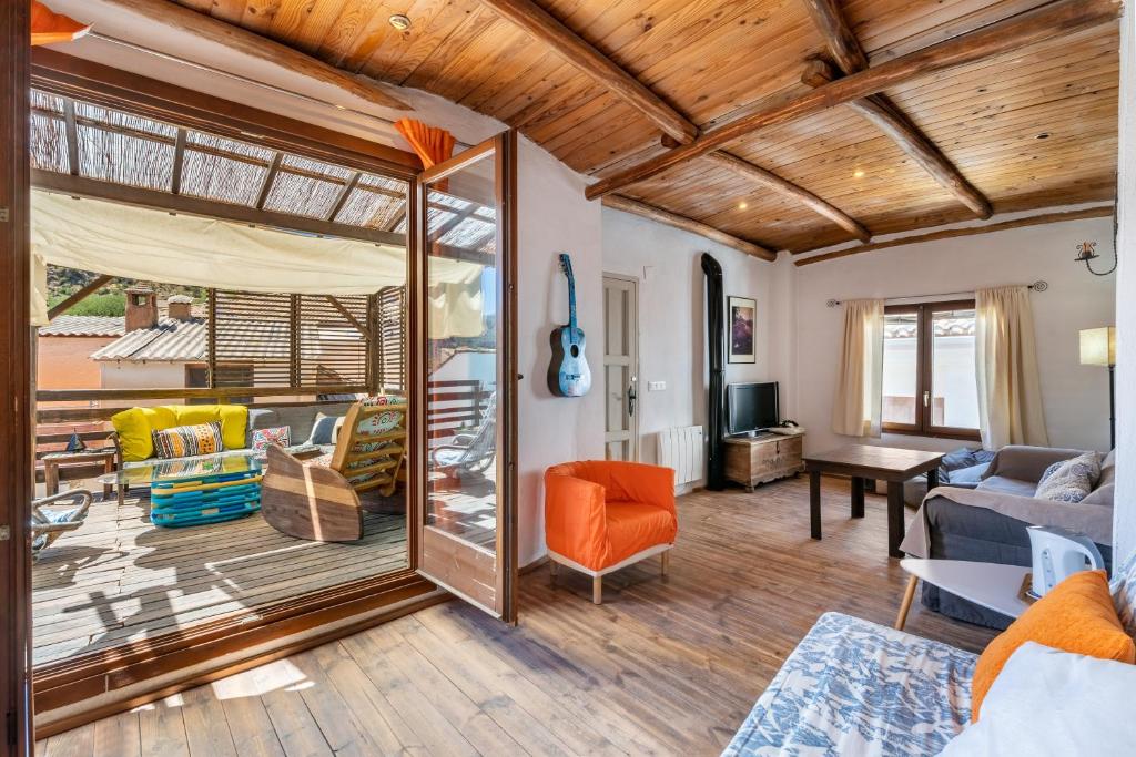 a living room with a large sliding glass door at La lechuga azul in Güéjar-Sierra
