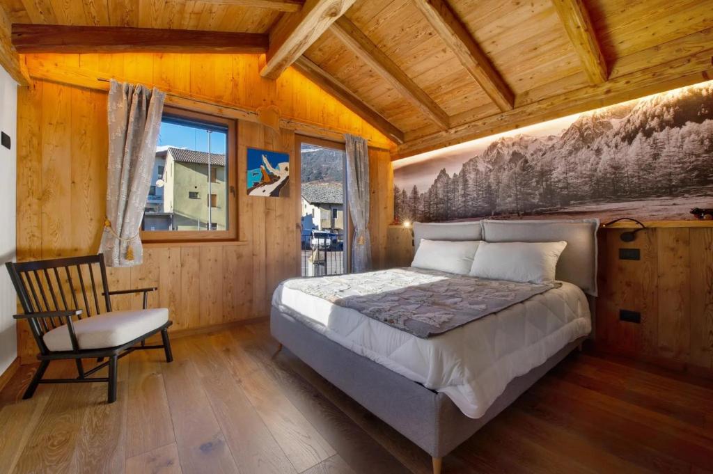 a bedroom with a bed and a chair in a room at Antirouille Casa Vacanze in Aymavilles