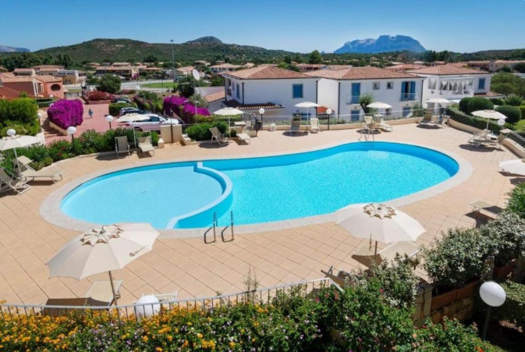a pool at a hotel with umbrellas at Lazulite - Sardinia Suite in Murta Maria