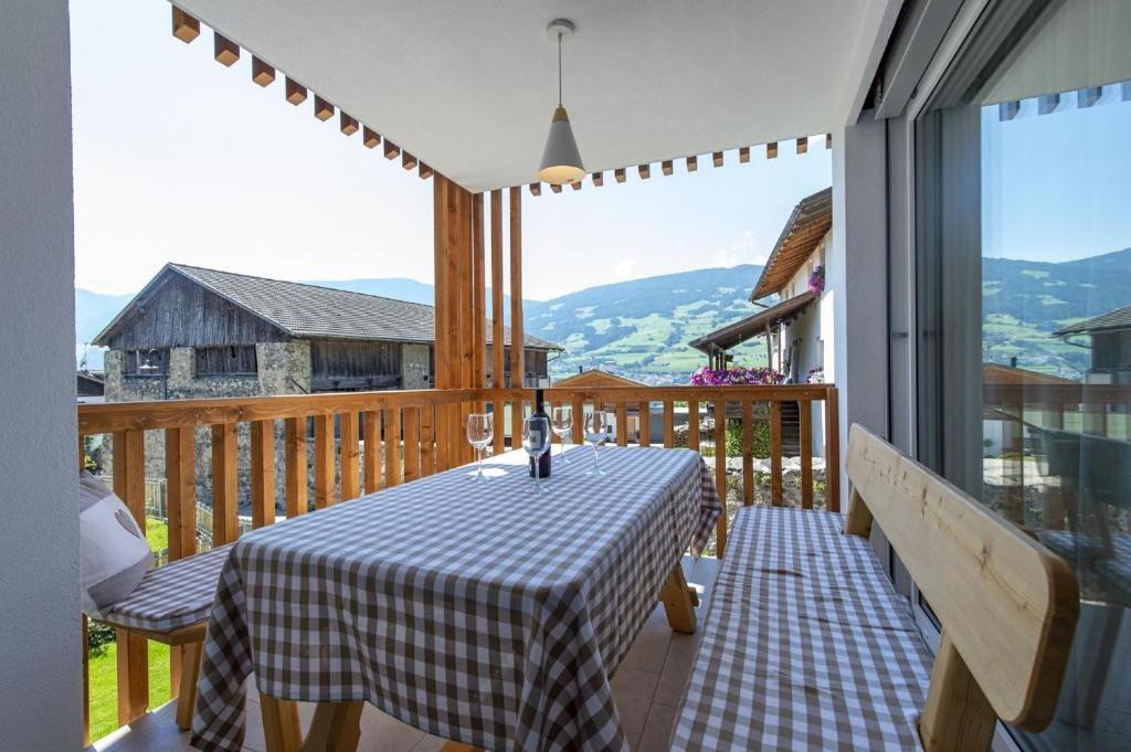 a table on a balcony with a view of the mountains at Gass Apartment A in Laion
