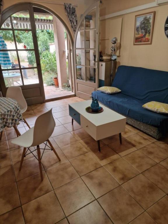 a living room with a blue couch and a table at Gite l'Embellido in Mouriès