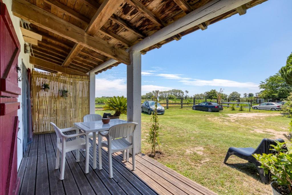 a patio with a table and chairs on a deck at Mas des Cypres - Mazet 7 in Saintes-Maries-de-la-Mer