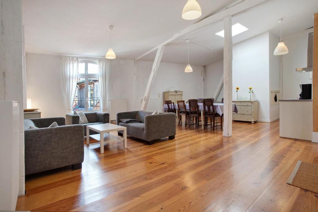 a living room with a couch and chairs and a table at Alte Seifensiederei - Ferienloft in Stralsund