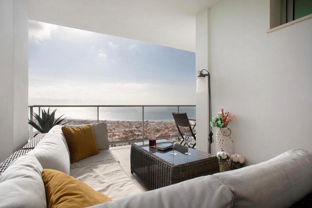 a living room with a couch and a view of the ocean at Sea view - dream Nazaré in Nazaré