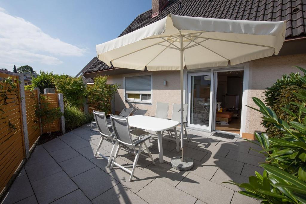 a table and chairs with an umbrella on a patio at Ferienwohnung Dr Saretz in Bodman