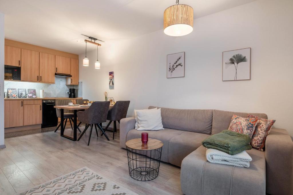 a living room and kitchen with a couch and a table at Fewo Seehase in Dorum-Neufeld