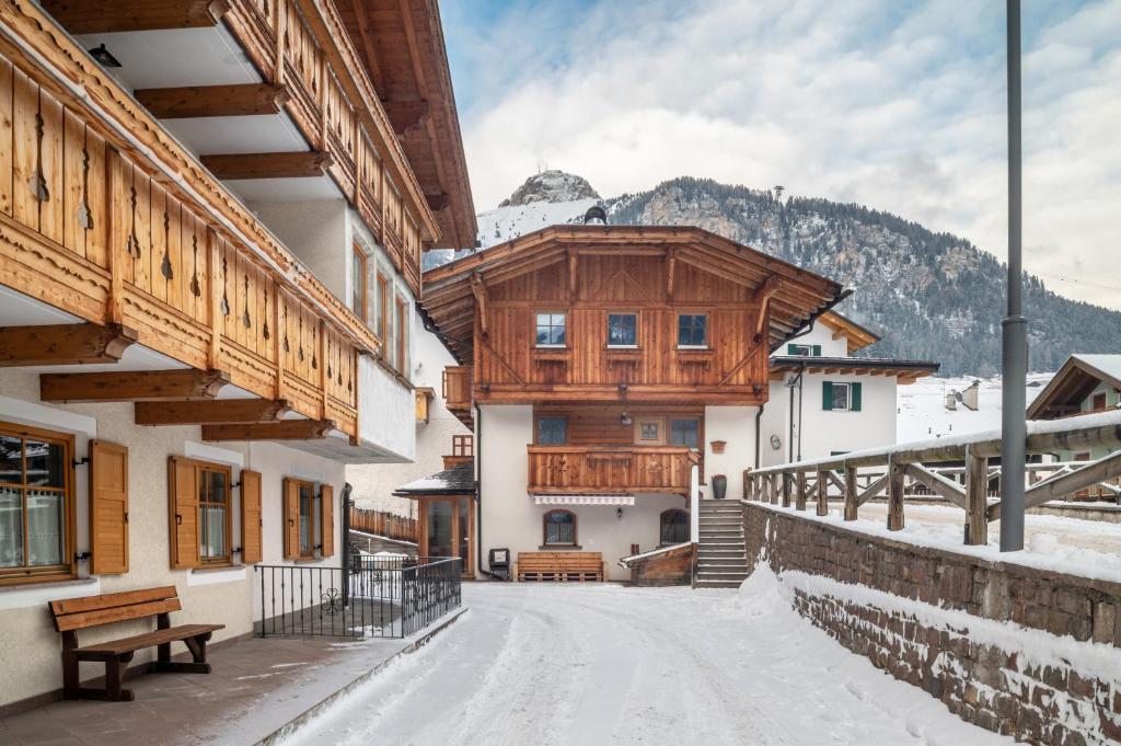 a house in the mountains with snow on the ground at Dolomitc Tobià in Campitello di Fassa