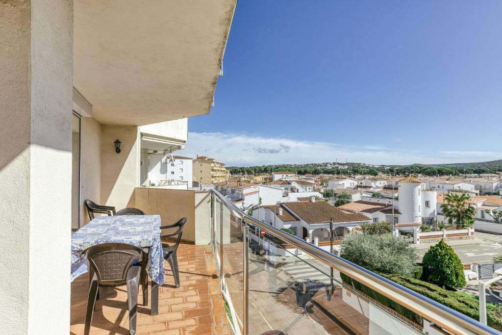 a balcony with a table and chairs and a view of a city at Escala Riells in L'Escala