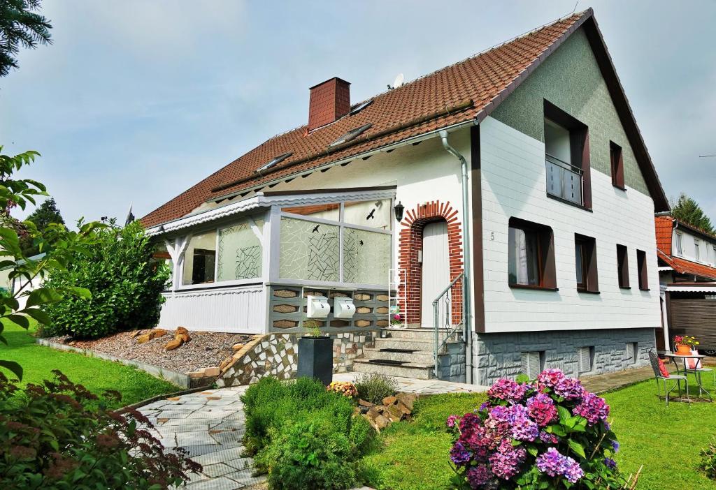 a white house with a yard with flowers at Ferienwohnung Schiller in Grebenhain