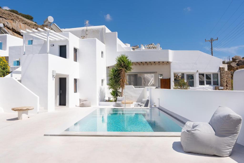 a white house with a swimming pool in front of it at Irene's Studio in Mikonos