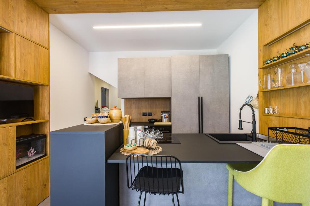 a kitchen with a counter with chairs in it at Gatto Matto in Brolo